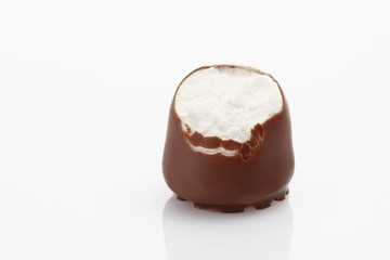 A bite taken from a chocolate-coated marshmallow treat