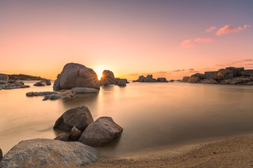Fototapeta na wymiar Sunrise over boulders and beach on Cavallo Island in Corsica
