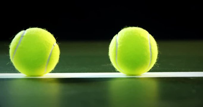 Tennis balls arranged on white line 