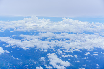 Scenery from airplane 's window seeing white clouds , blue sky and landscape of Thailand 's countryside