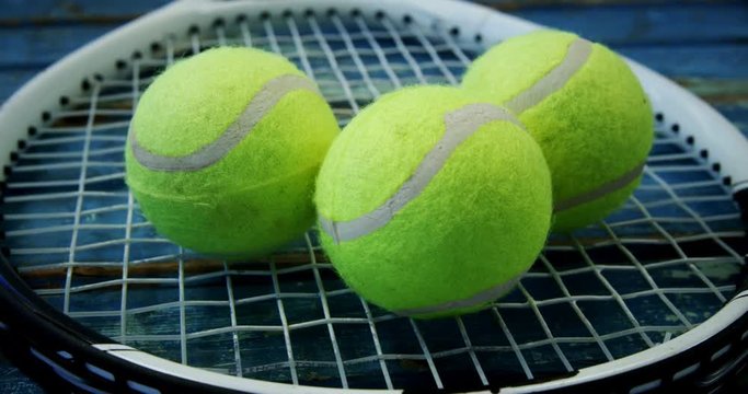 Three tennis balls on racket 