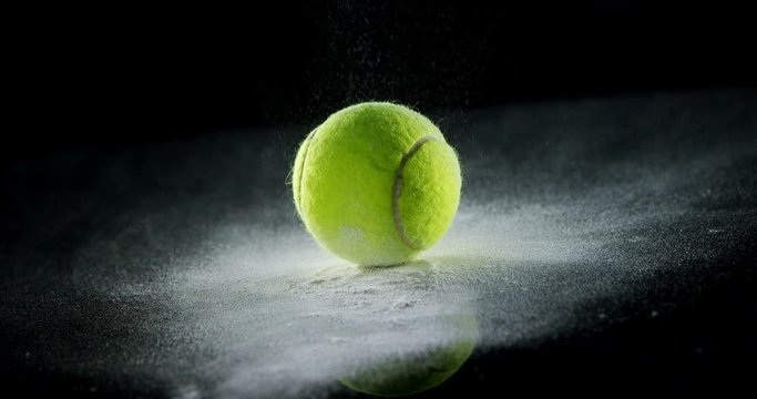 Bouncing ball with powder on black background