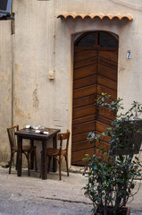 Corsica, 05/09/2017: un tavolo di ristorante tra i vicoli della città vecchia di Bonifacio, comune del sud dell’isola costruito su alte scogliere di calcare bianco