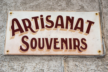 Corsica, 05/09/2017: l'insegna di un negozio di souvenir e artigianato in un vicolo della città vecchia di Bonifacio