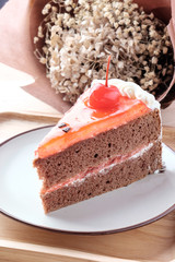 Piece of cake in a dish on a wooden tray