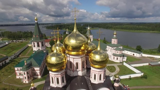 Valday Iversky Russian Orthodox Monastery golden domes. UNESCO historical unique Lake Seliger. Flight around domesaerial drone. Beautiful nature summer day clouds horizon.