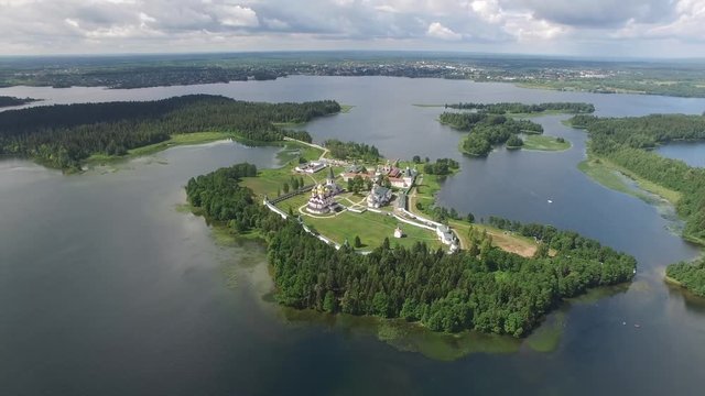 Valday Iversky Russian Orthodox Monastery. Valdaysky National Park UNESCO Biosphere Reserve Lake Seliger reflections. Flight around aerial drone. Beautiful nature summer clouds horizon.