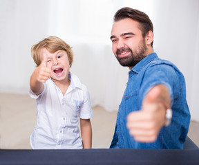 happy family portrait - young father and his cute little son thumbs up