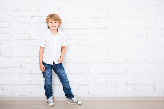 full length portrait of cute little boy posing over white