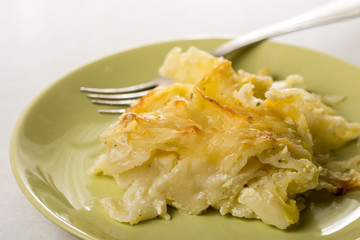 Gratinated macaroni with cheese served on the green plate