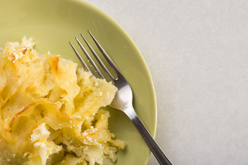 Gratinated macaroni with cheese served on the green plate