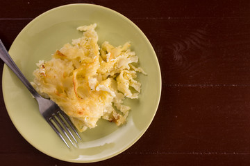 Crisp macaroni with cheese grated in the oven, served on the plate above white marble background