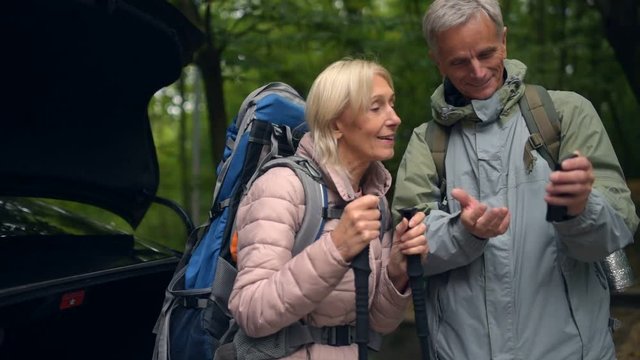 Pleasant elderly couple strating their trip in the forest