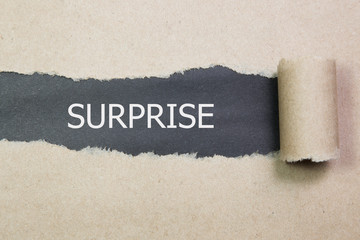 SURPRISE word written under torn paper.
