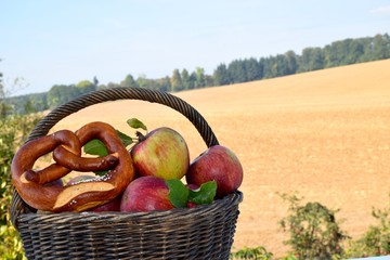 Korb mit Äpfeln und Brezel