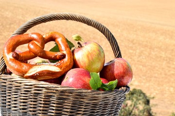 Korb mit Äpfeln und Brezel