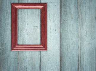 Blank frame on wooden wall