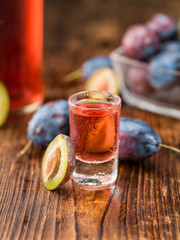 Fresh made Plum Liqueur on a rustic background