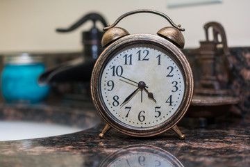 Rustic bell alarm clock in bathroom