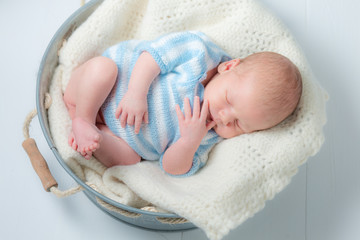Cute newborn infant sleeping in small bath