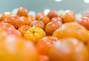 Macro closeup of display of many tangerine oranges in store