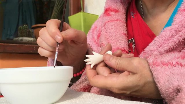 The master artist processes for doll's billet. Making and processing of hands and fingers.