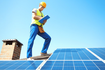 Worker installing solar panels outdoors