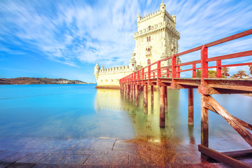 Scenic Belem Tower and wooden dock reflects with low tides on Tagus River.Torre de Belem is Unesco...