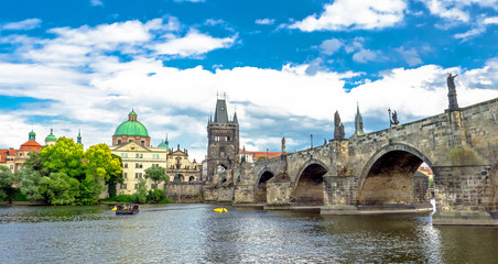 Fototapeta na wymiar Landscape of the romantic city of Prague under a blue sky. Panoramic view of Charles bridge and old town on a summer day in the capital Czech Republic. Cruise on the Moldovan river. 