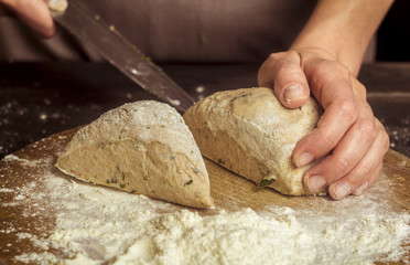 The baker cuts the dough.
