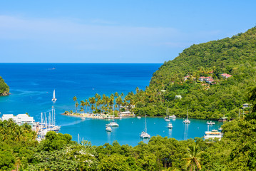 Marigot Bay, Saint Lucia, Caribbean. Tropical bay and beach in exotic and paradise landscape scenery. Marigot Bay is located on the west coast of the Caribbean island of St Lucia. - obrazy, fototapety, plakaty