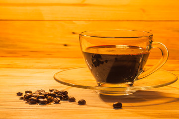 transparent coffee cup and on pinewood table.