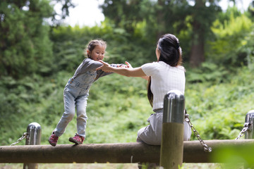 Fototapeta premium Mother and daughter playing in the park