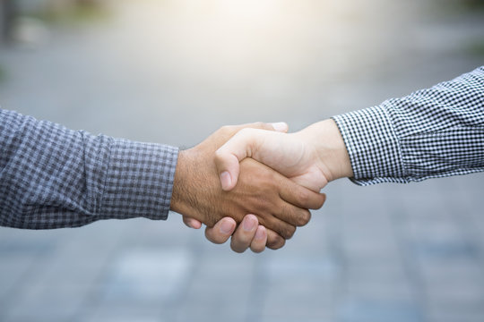 business hand shake between two colleagues Plaid shirt. or Negotiate agreement.Good deal. Close-up of handshaking. Smooth business.
