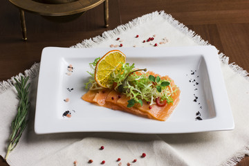Thin pieces of salted salmon under the greens with the oranges