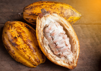 Cocoa beans and cocoa pod on a wooden surface.