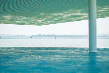 Fototapeta na wymiar Sea view from a concrete pier covered with a perforated roof.