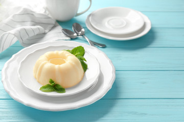 Plate with delicious vanilla pudding on wooden table