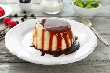 Delicious vanilla pudding with chocolate syrup on plate