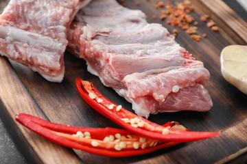 Wooden board with fresh raw meat, closeup
