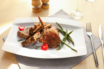 Plate with grilled meat on table