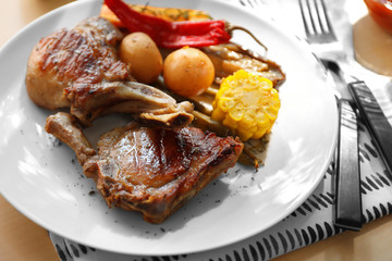 Plate with grilled meat on table