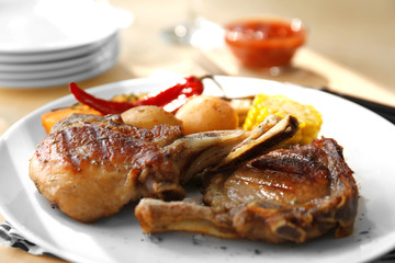 Plate with grilled meat on table