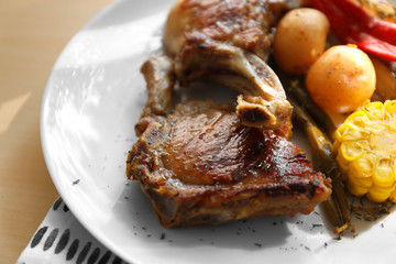 Plate with grilled meat on table