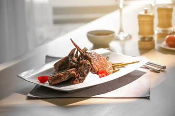 Plate with grilled meat on table