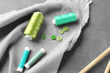 Green sewing threads and buttons on table