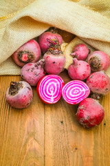 Chioggia striped or candy stripe beet whole and sliced in burlap sack on wooden table, selective focus