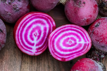 Chioggia striped or candy stripe beet whole and sliced in burlap sack on wooden table, selective...