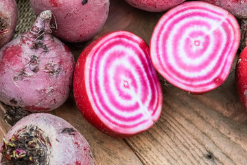 Chioggia striped or candy stripe beet whole and sliced in burlap sack on wooden table, selective focus