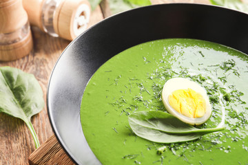 Plate with delicious spinach soup on table